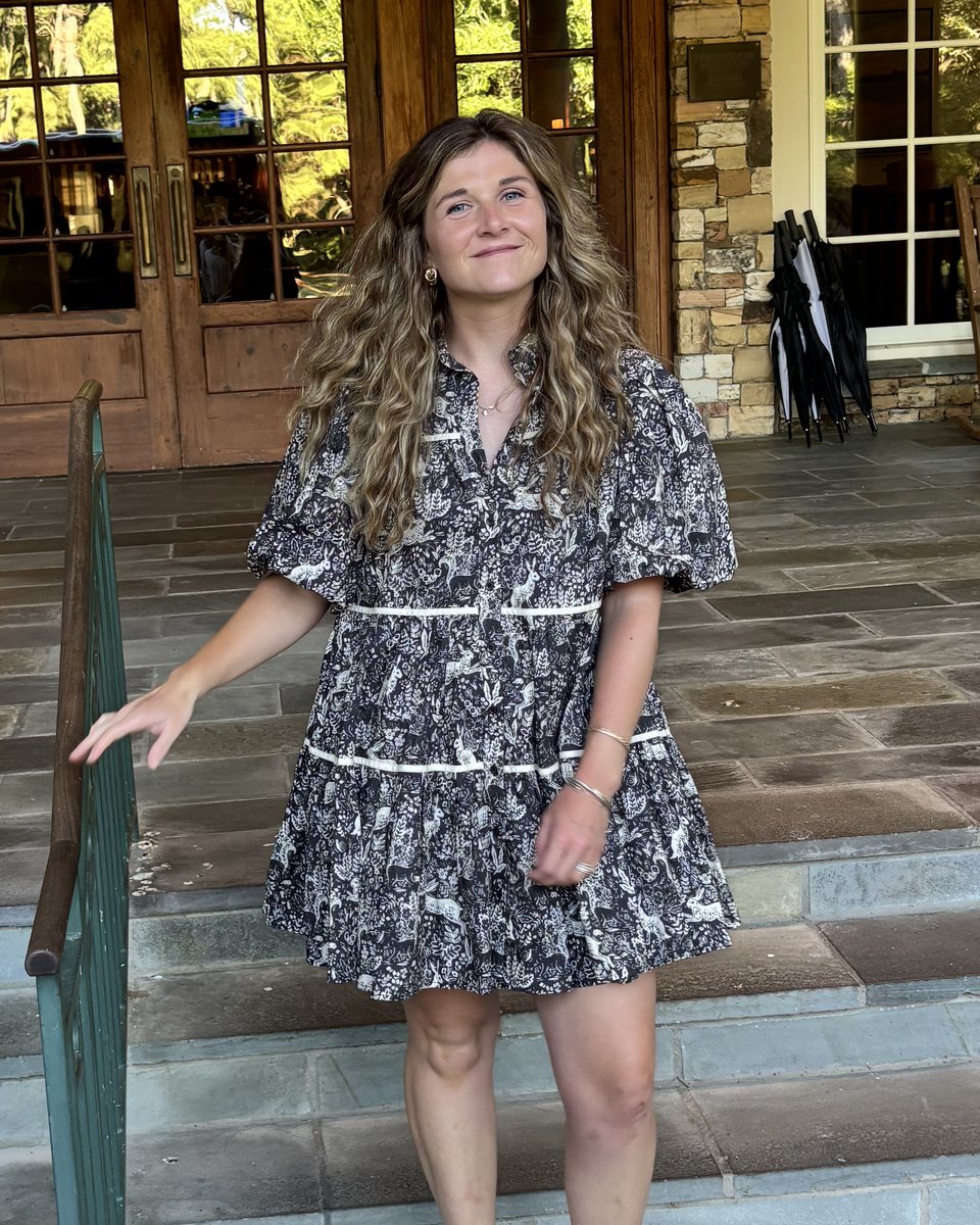 Molly Brewer on stone steps in a black and white toile dress